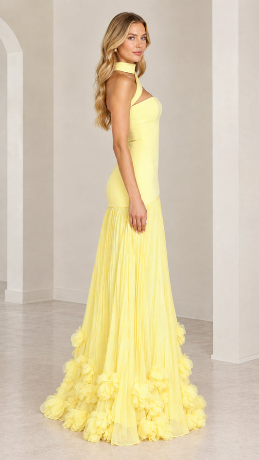 Side angle view of the yellow drop-waist maxi gown with rosette hem