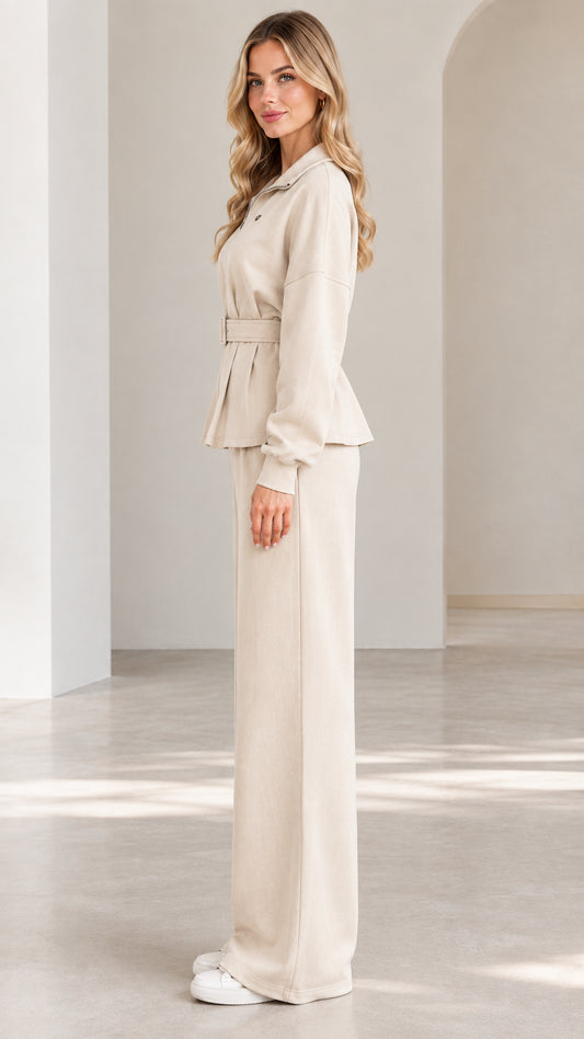 Side full-length view of woman wearing beige belted two-piece matching set