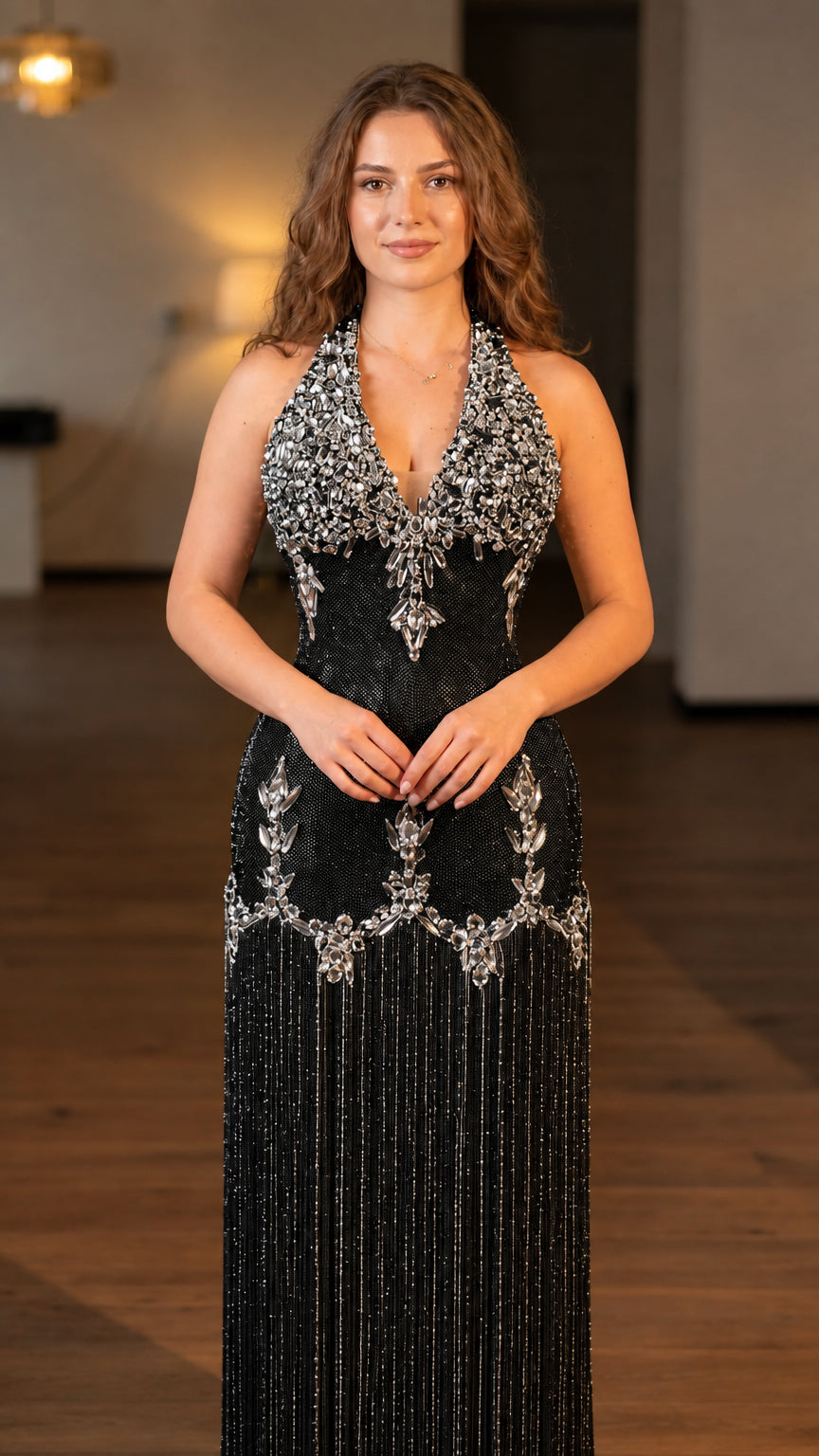Model wearing black rhinestone embellished halter fringe maxi evening gown