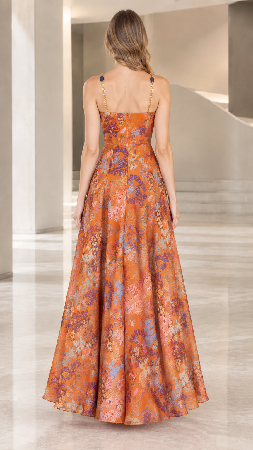 Back view of model in a rust floral maxi dress with delicate chain straps