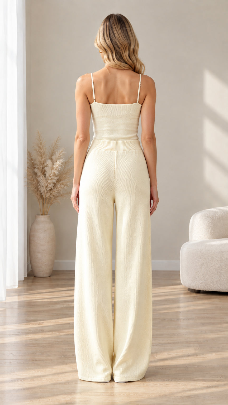 Back view of woman wearing cream ribbed camisole and high-waist wide-leg trousers