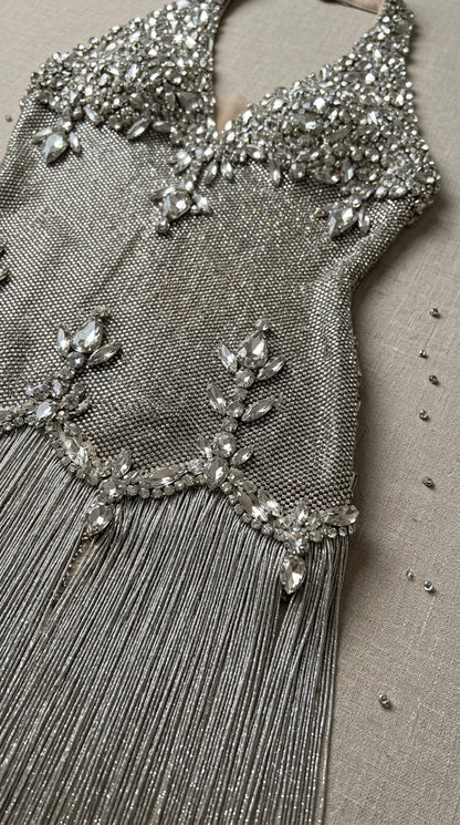 Close-up detail of silver crystal rhinestone embellishments and delicate tiered fringe trim