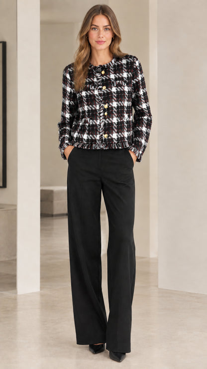 Model wearing black and white plaid tweed cropped jacket with gold buttons