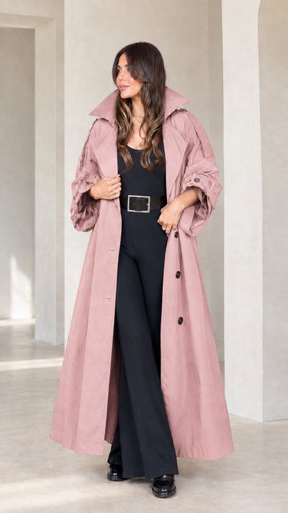 Front view of woman wearing dusty pink maxi trench coat with gathered sleeves